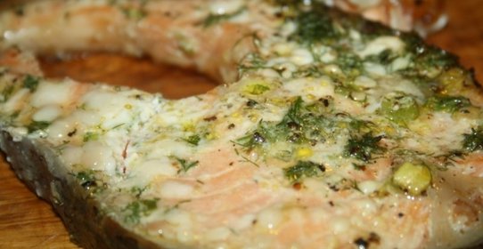 Лосось с толченой зеленью на гриль-доске на мангале