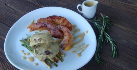 Телятина, тушенная в соусе чипотле, с глазированной айвой и зеленым пером чеснока на гриле