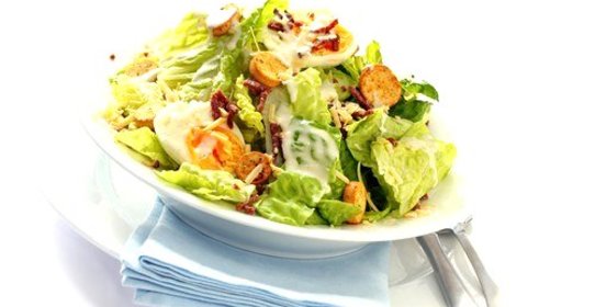 Салат «Цезарь» с желтыми помидорами черри и изюмом