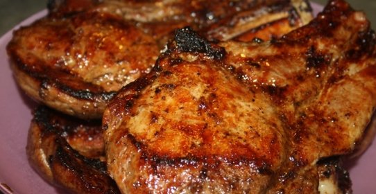 Сочные острые стейки рибай на мангале на решетке.